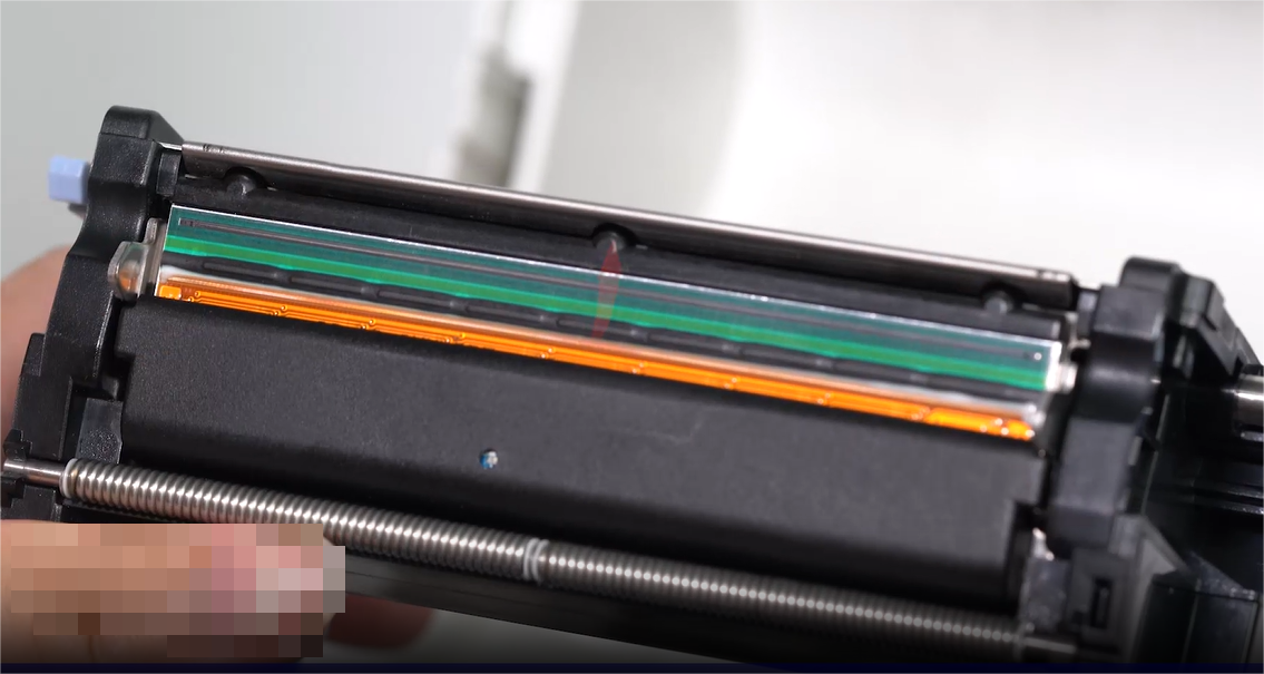 Tá close-up of a person carefully cleaning an electronic component with a swab.